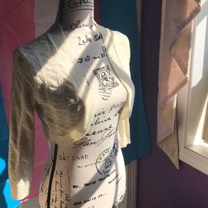 A white and gold knitted shrug